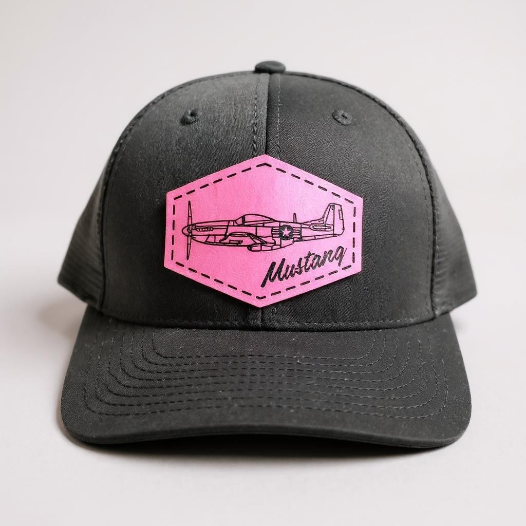 Black trucker hat with a blue patch featuring an airplane and 'Mustang' text on a white background.