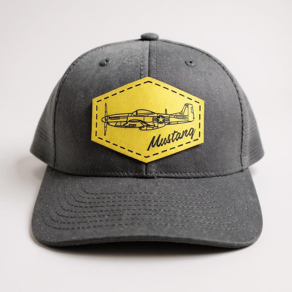 Black trucker hat with green patch featuring the word "Mustang" and the airplane design on a white background