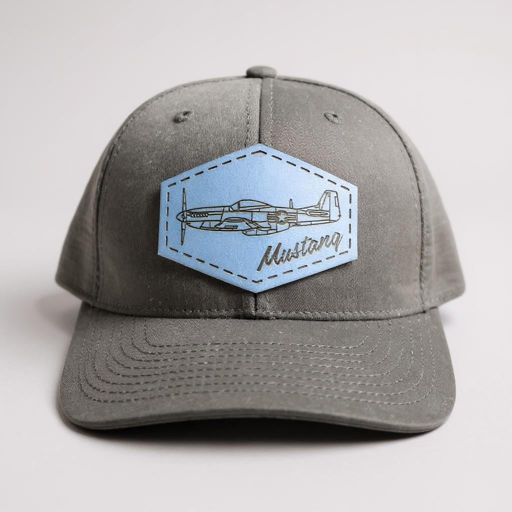 Black trucker hat with a blue patch featuring an airplane and 'Mustang' text on a white background.