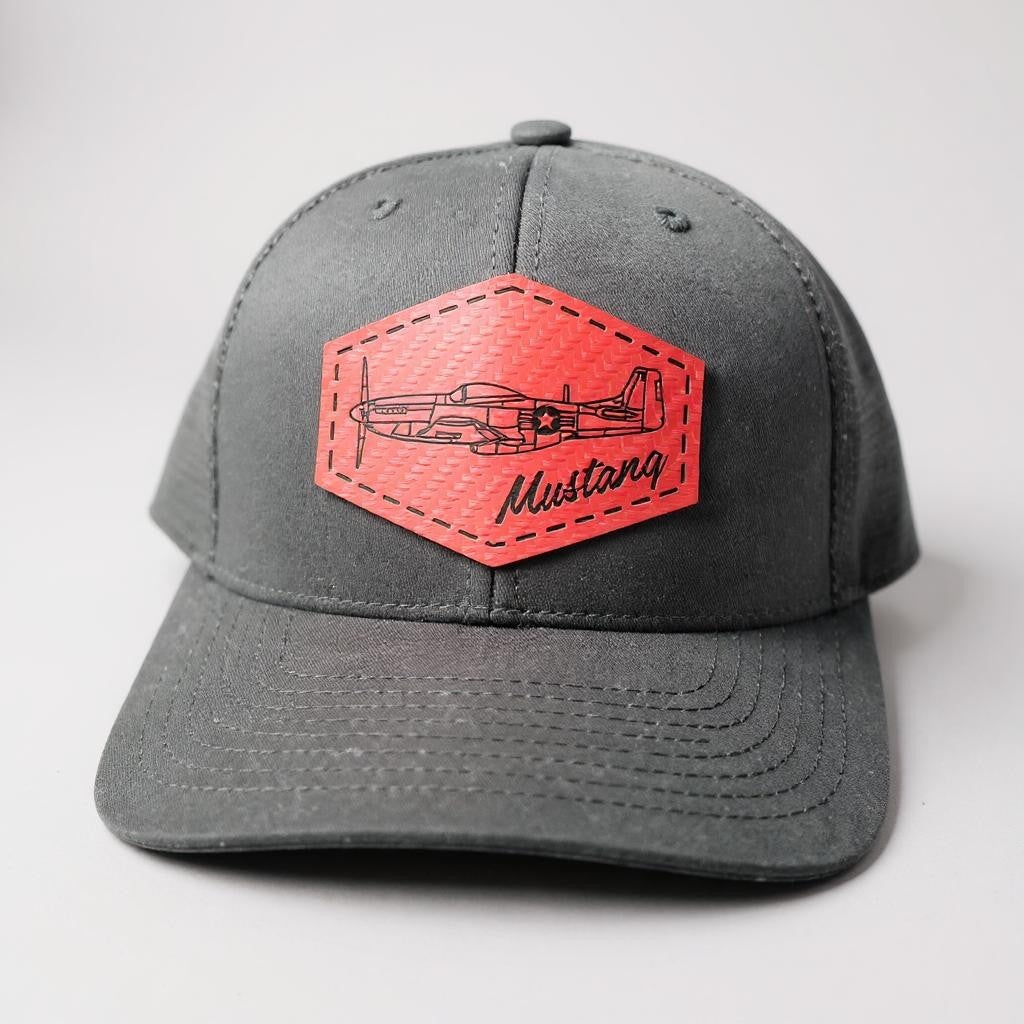 Black trucker hat with a red patch featuring an airplane and 'Mustang' text on a white background.