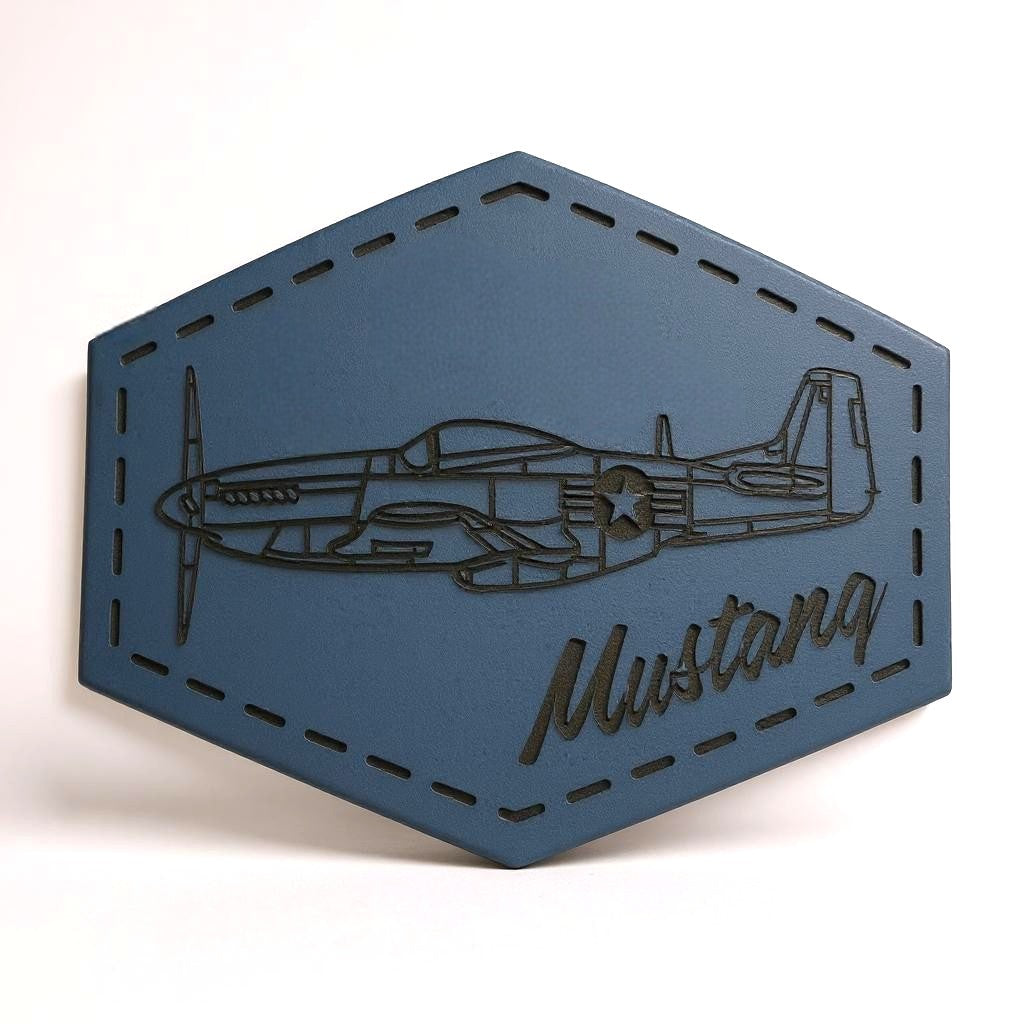 Hexagonal blue leather patch with airplane design and 'Mustang' text on a white background